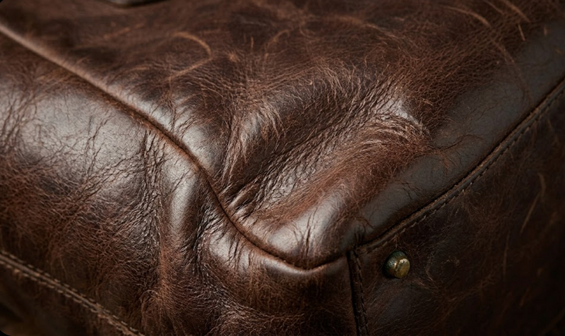 Close-up of aged full grain leather showing natural patina and soft creases
